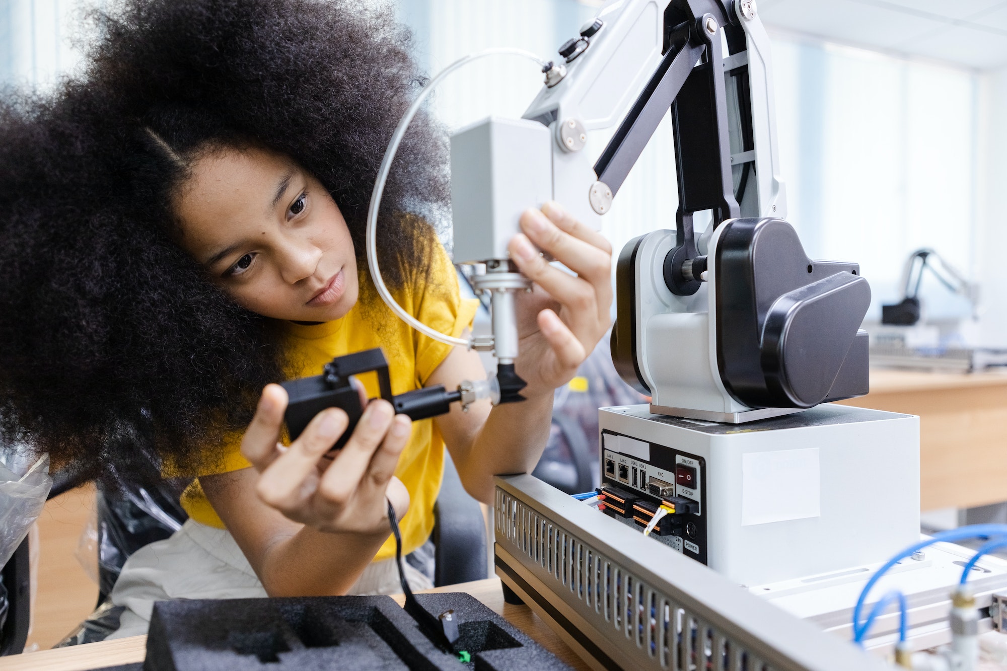 Girl with afro hairstyle wear yellow T-shirt engineer with robot for education